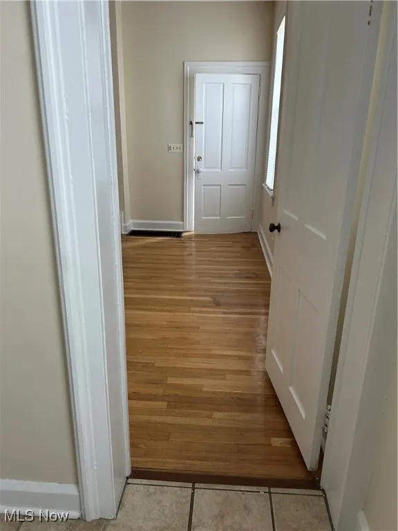 Corridor with baseboards and tile patterned flooring