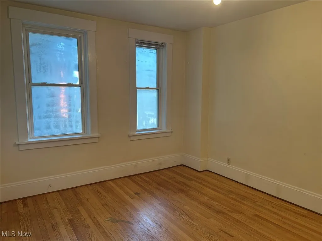 Unfurnished room with baseboards and light wood-style floors