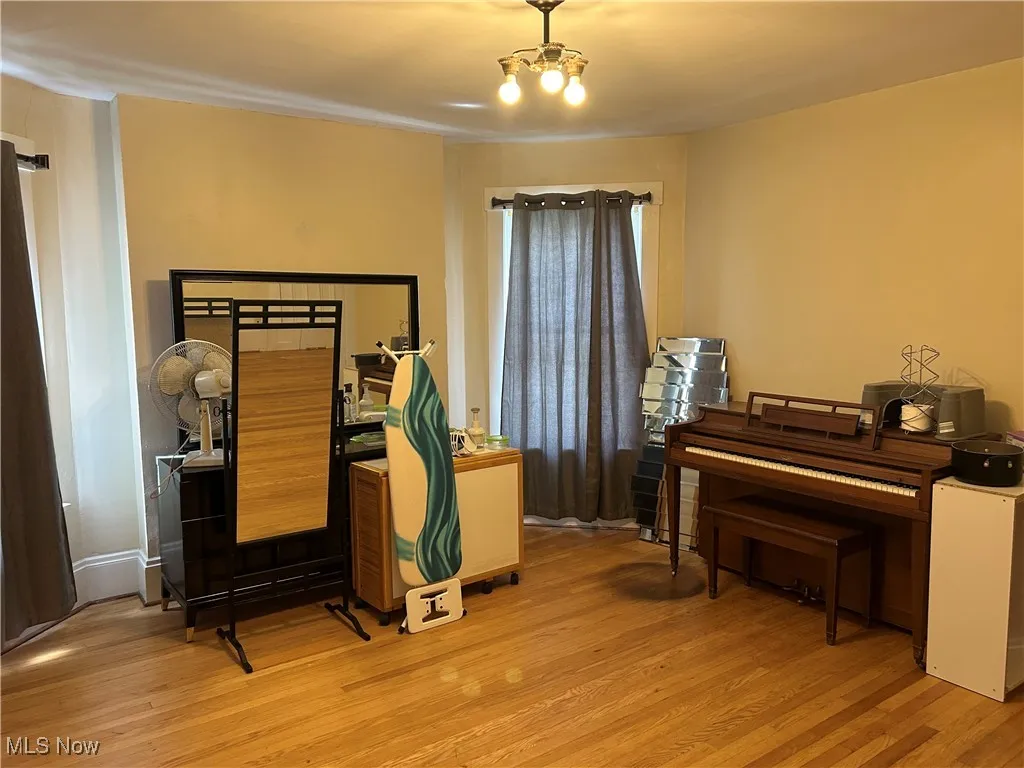 Bedroom with light wood finished floors and a chandelier
