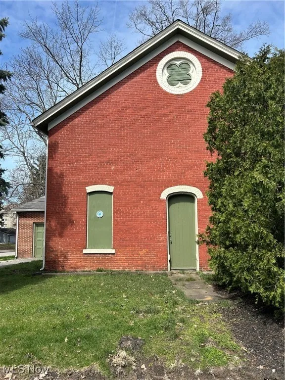 View of front of house featuring brick siding and a front lawn