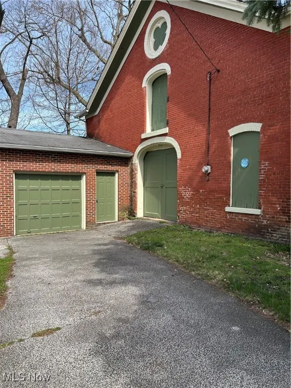 View of front facade with brick siding and driveway
