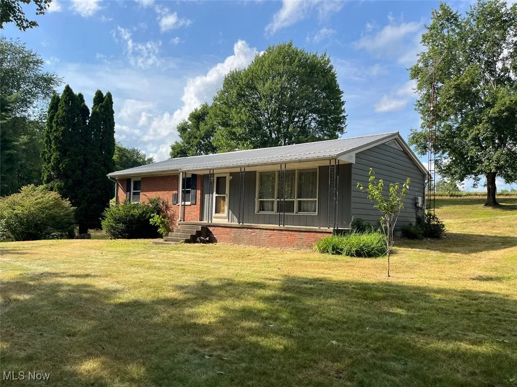 Single story home featuring a porch, a front yard, and brick siding