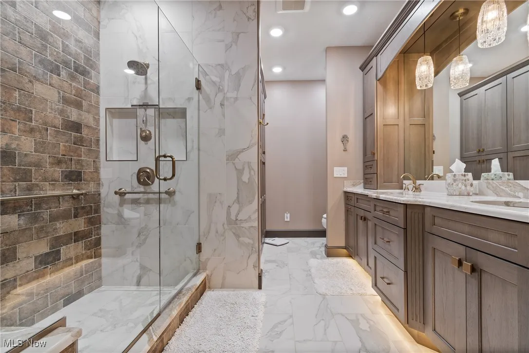Primary bath with custom tile shower, dual sinks, undercabinet toe lighting
