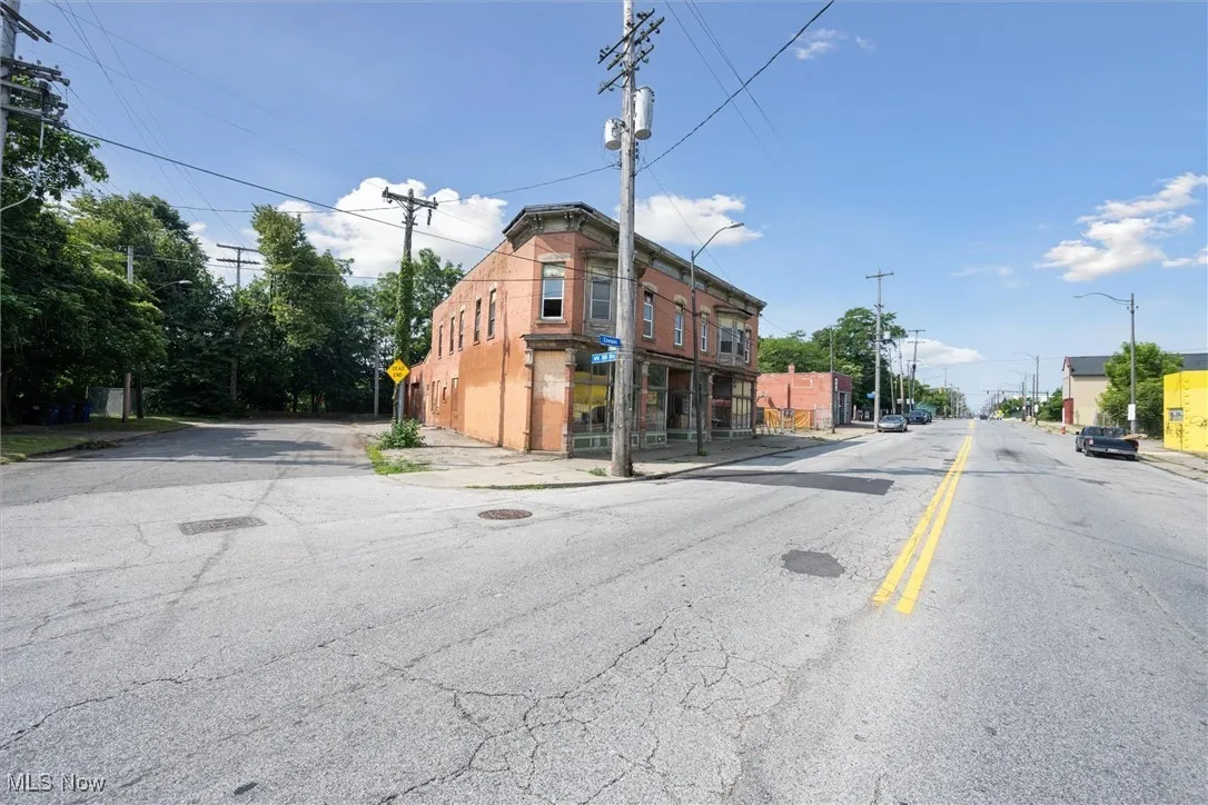 View of asphalt street with street lights, sidewalks, traffic signs, and curbs
