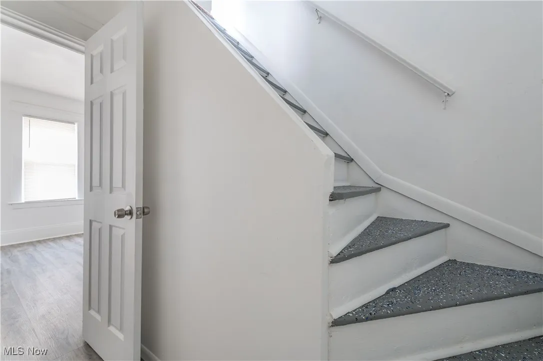 Staircase with baseboards and wood finished floors