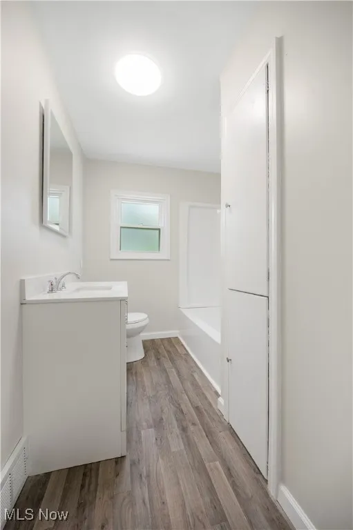 Full bath with vanity, wood finished floors, and  shower combination