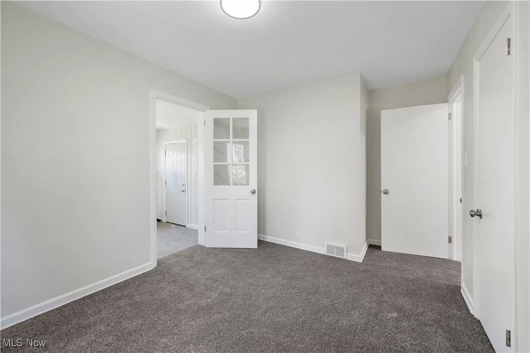 Carpeted spare room with baseboards