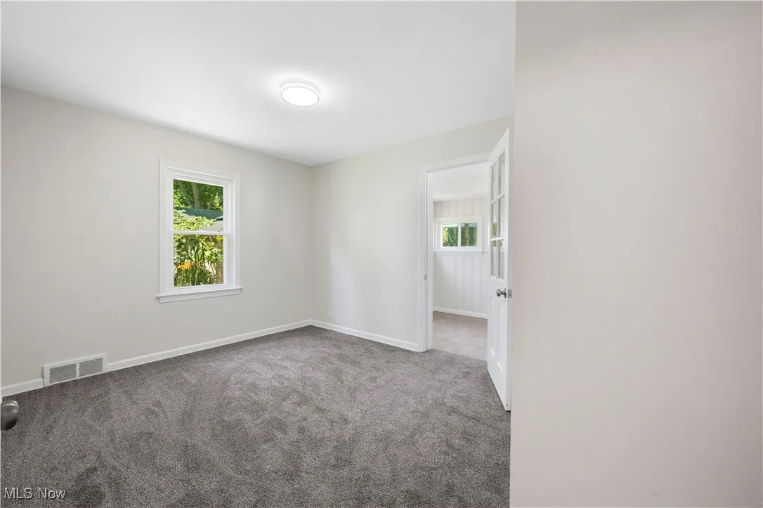 Carpeted empty room with baseboards