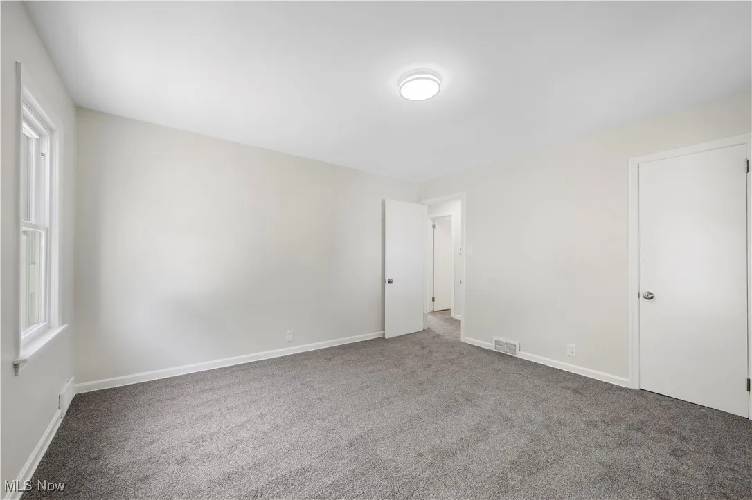 Unfurnished bedroom with carpet floors and baseboards