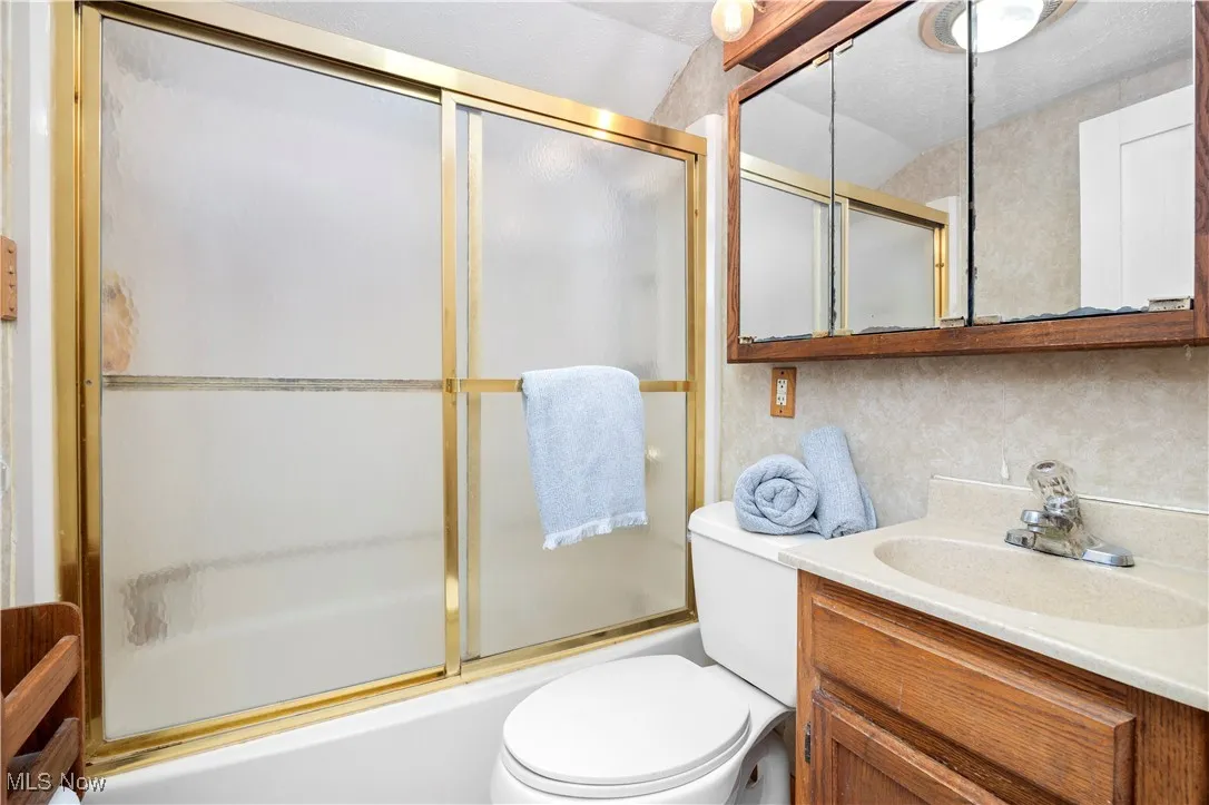 Full bathroom with vanity and shower / bath combination with glass door