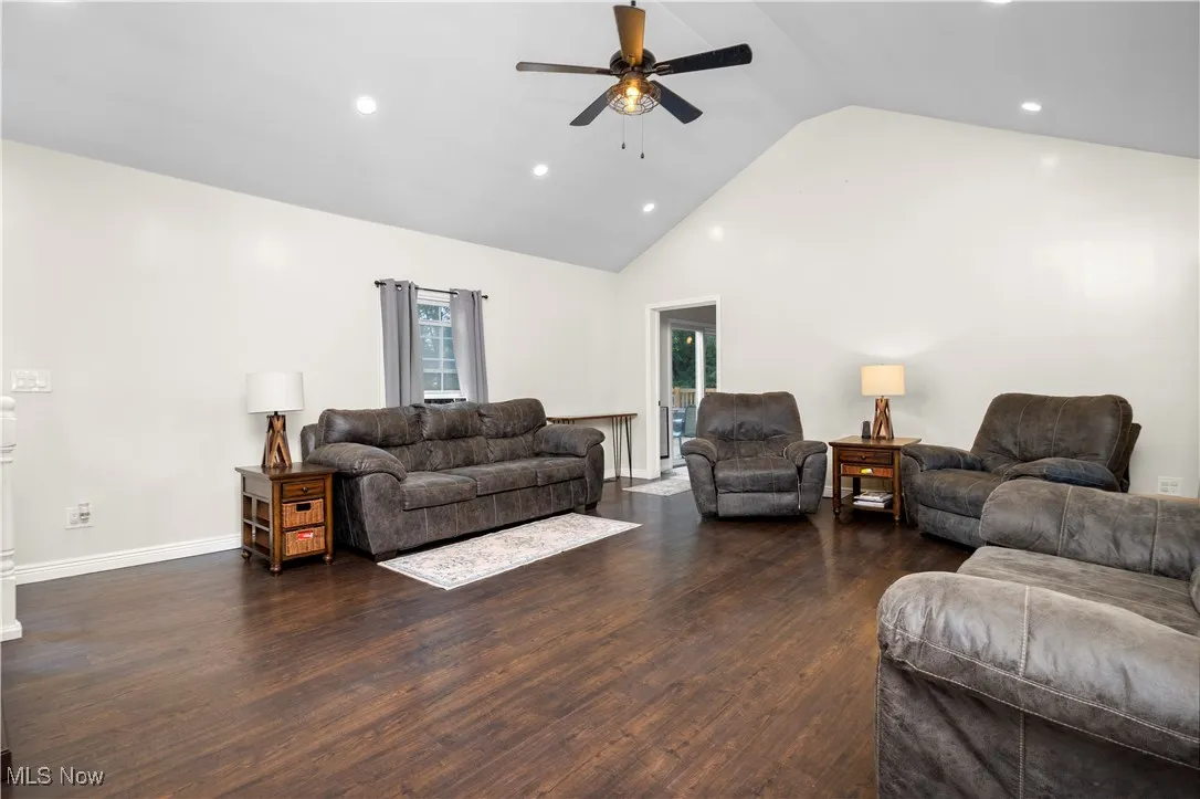 Living area with recessed lighting, a ceiling fan, wood finished floors, and high vaulted ceiling
