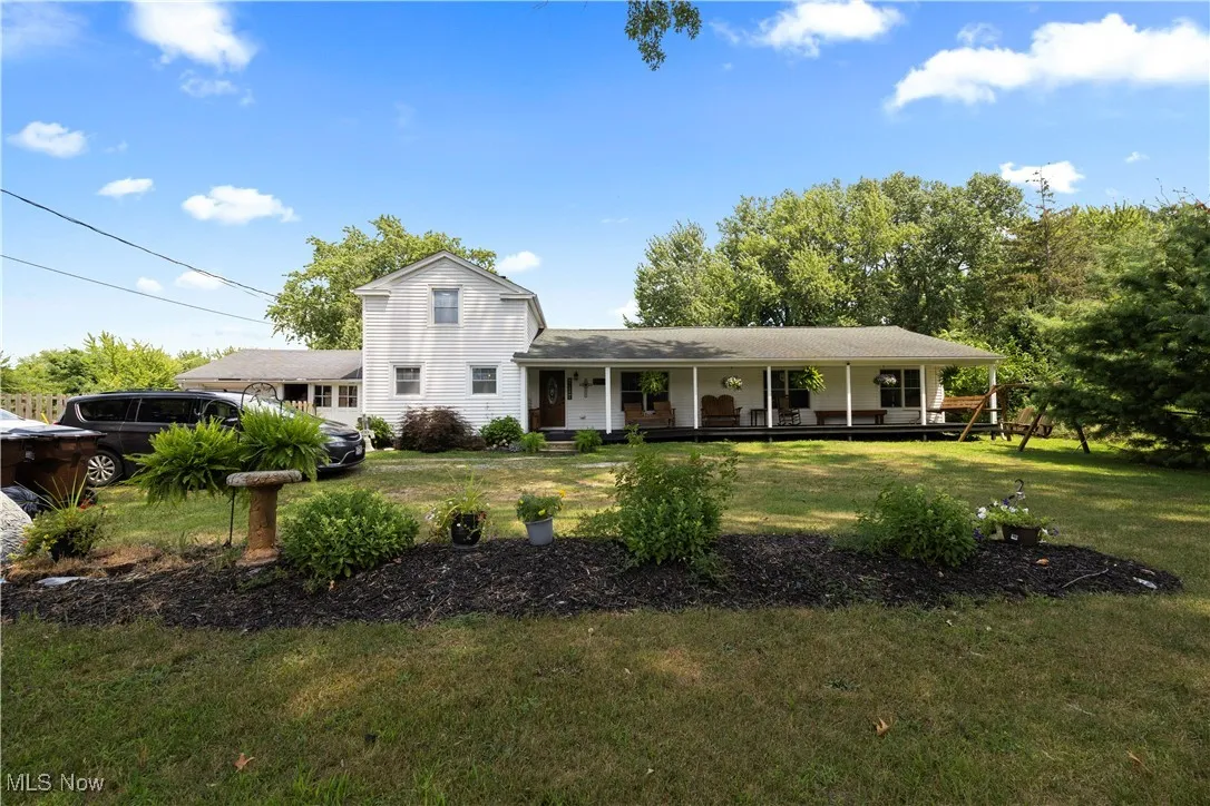 View of front of property featuring covered porch and a front yard