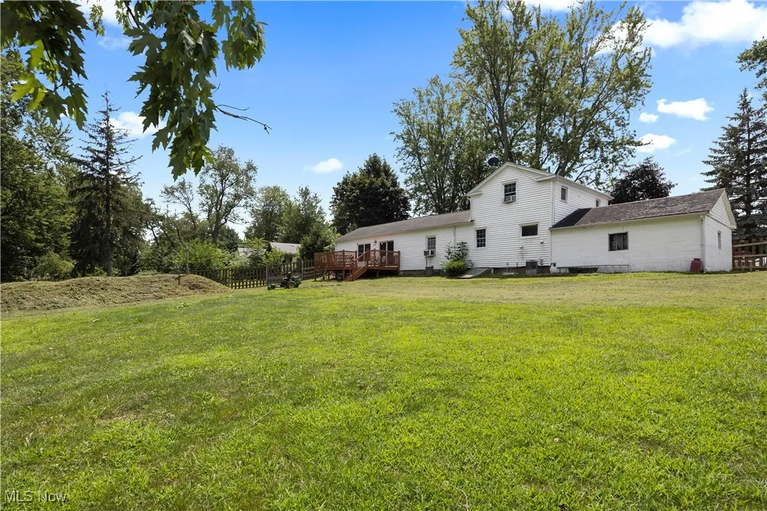 View of grassy yard featuring a deck