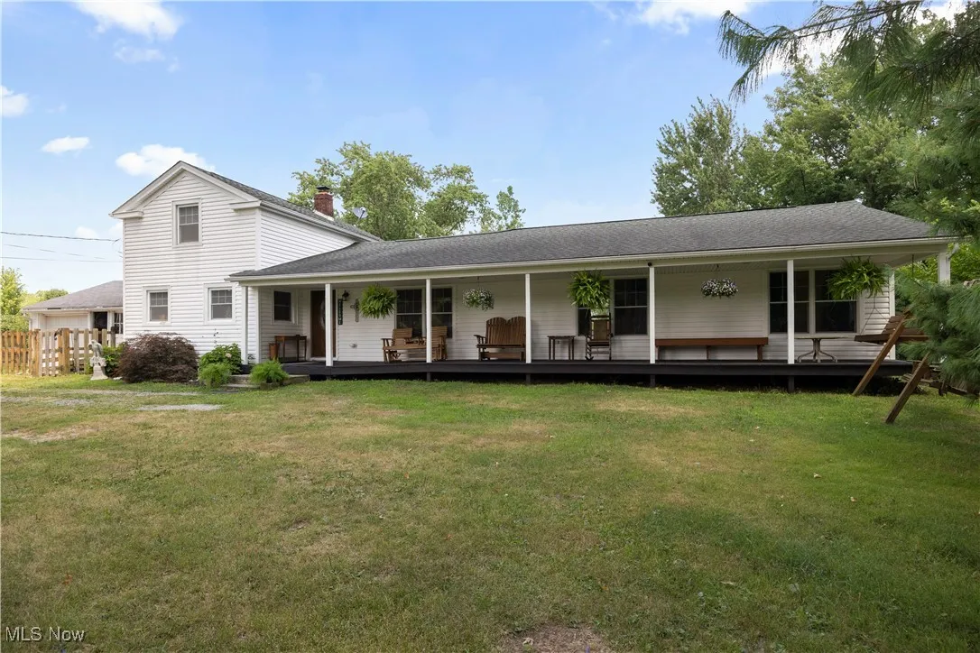 View of front of home with a porch, a chimney, and roof with shingles