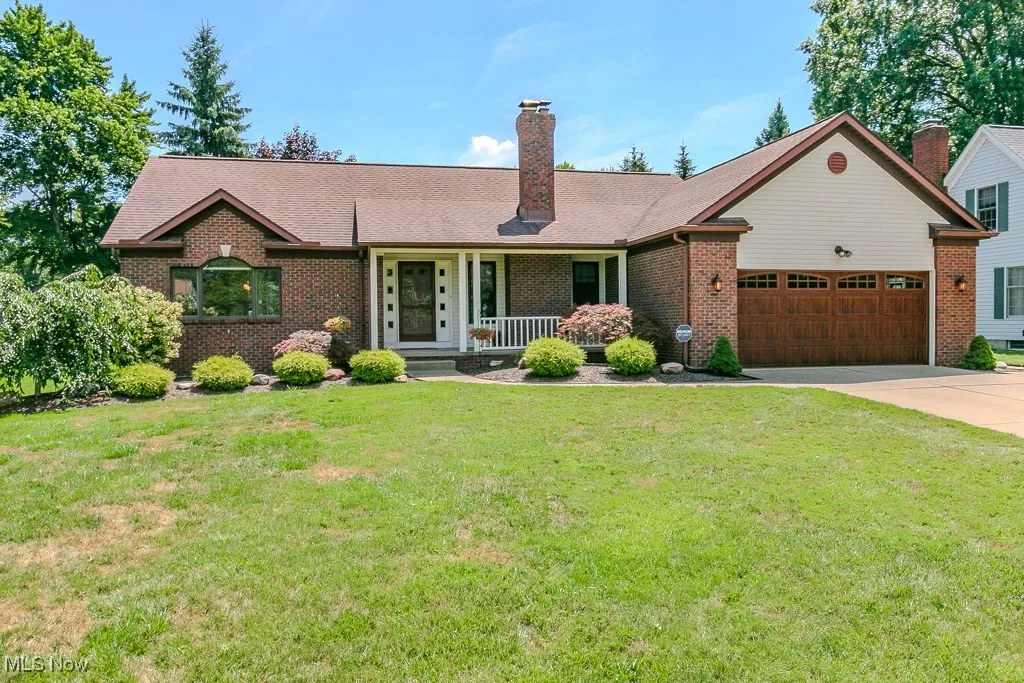 Ranch home with an attached garage, a porch  and a brick front
