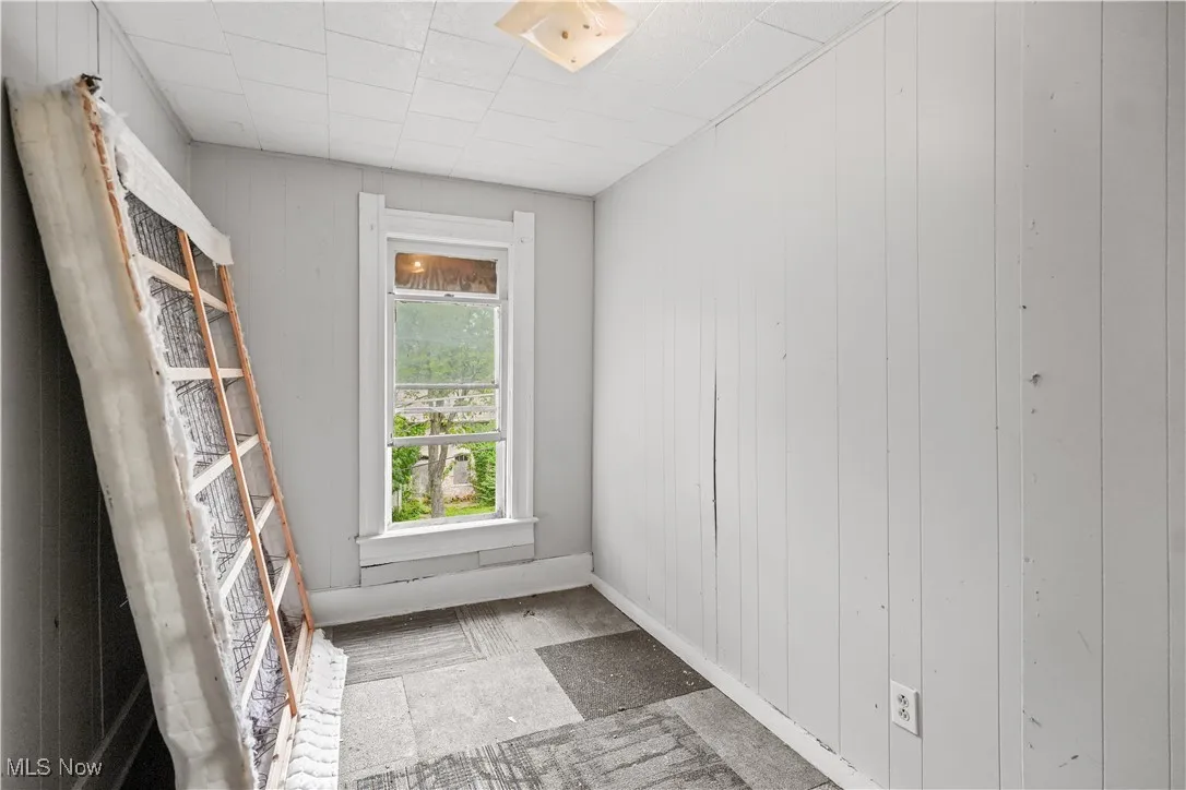 Spare room with wooden walls and baseboards