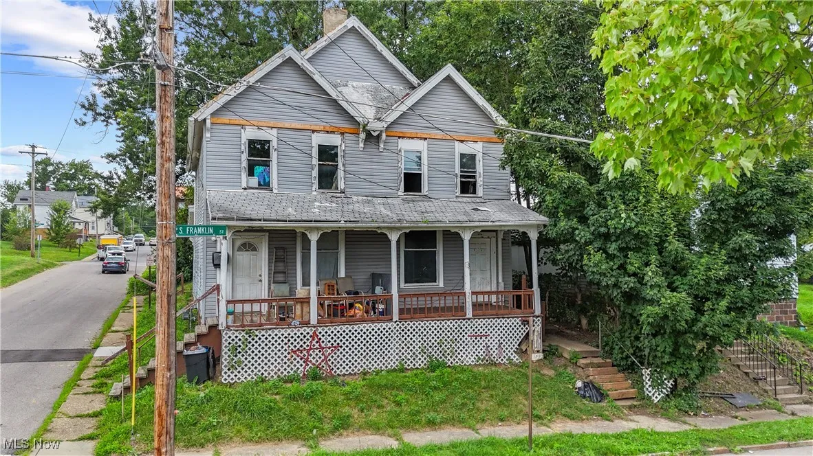 View of front of property featuring covered porch and stairway