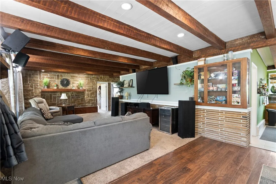 Living room featuring wood finished floors, beam ceiling, beverage cooler, and recessed lighting