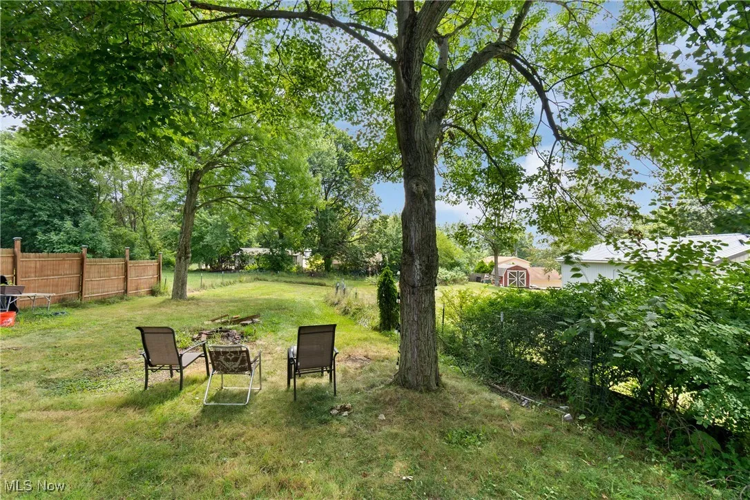 View of yard with an outdoor fire pit and view of scattered trees
