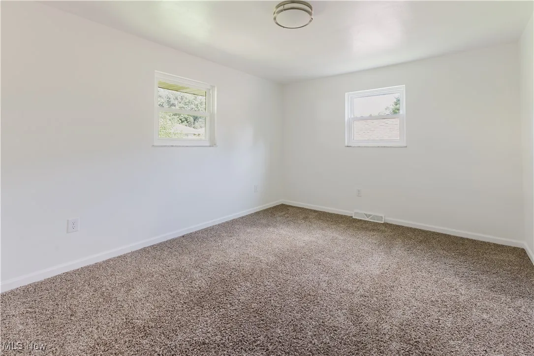 Unfurnished room with carpet floors and baseboards