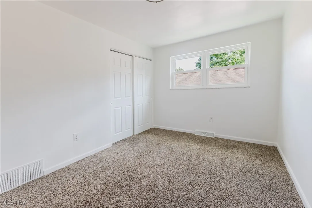 Unfurnished bedroom featuring a closet and carpet floors