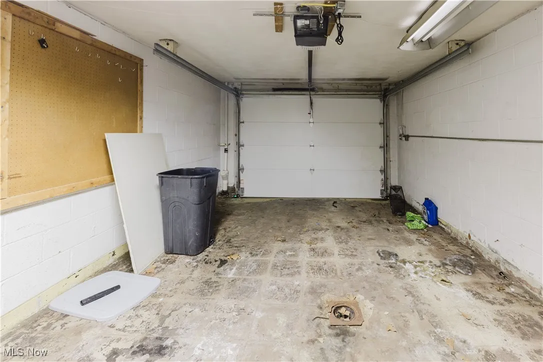 Garage featuring concrete block wall and a garage door opener