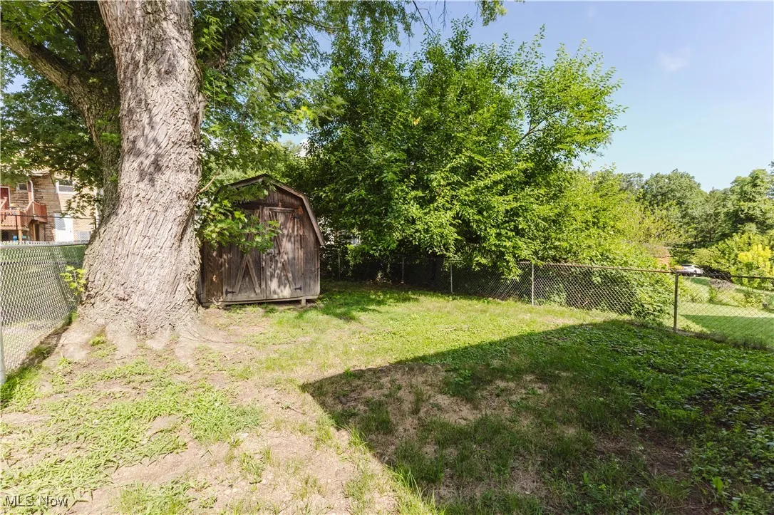 Fenced backyard featuring a storage shed