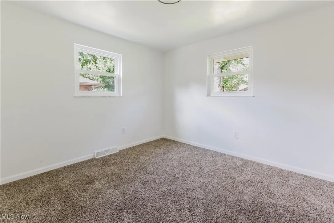 Carpeted empty room featuring plenty of natural light