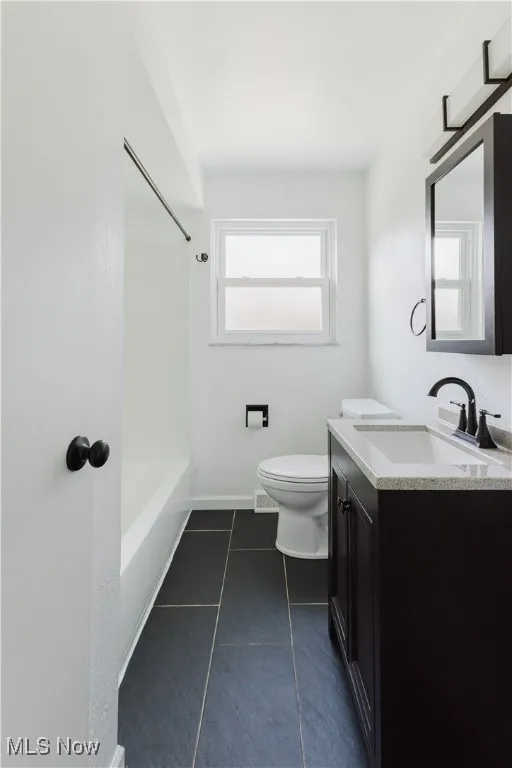 Full bathroom with vanity, tile patterned flooring, and washtub / shower combination