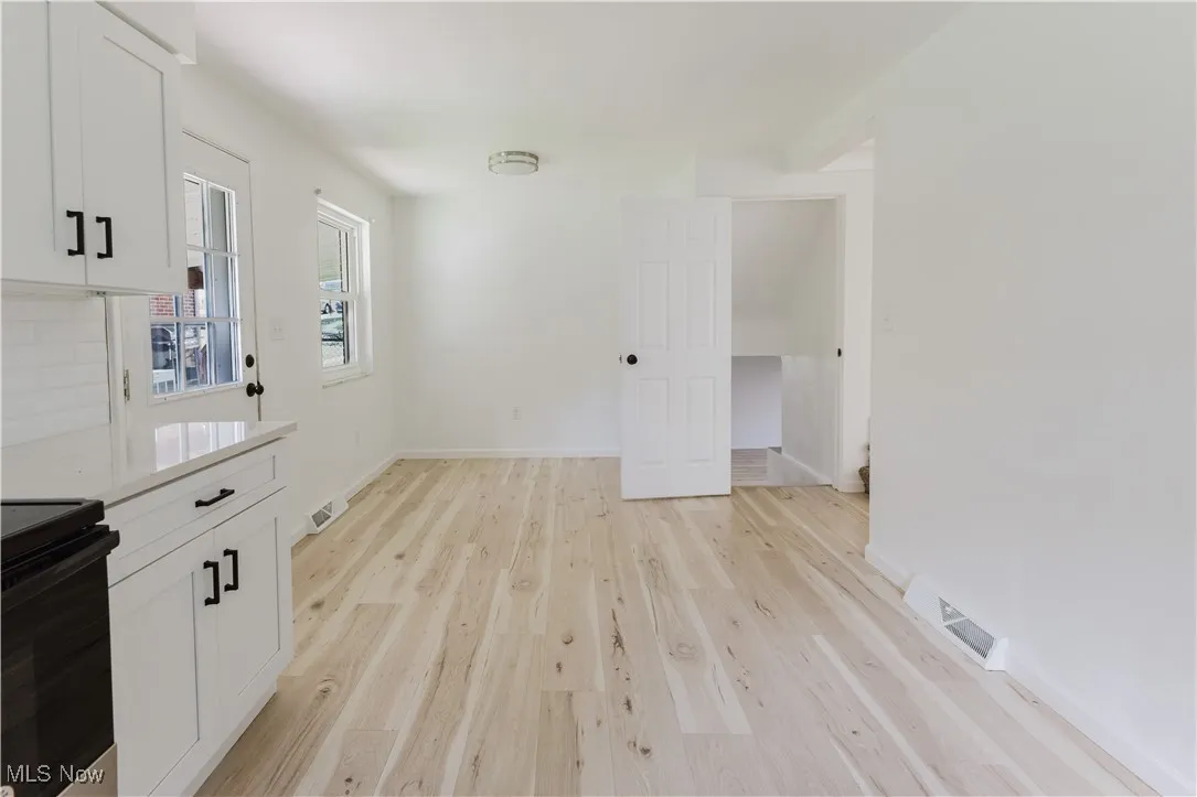 Unfurnished dining area with light wood finished floors and baseboards