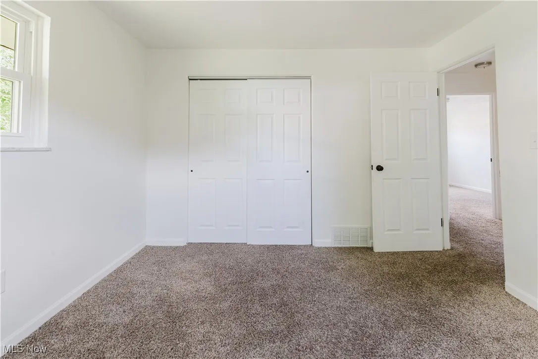 Unfurnished bedroom with carpet and a closet