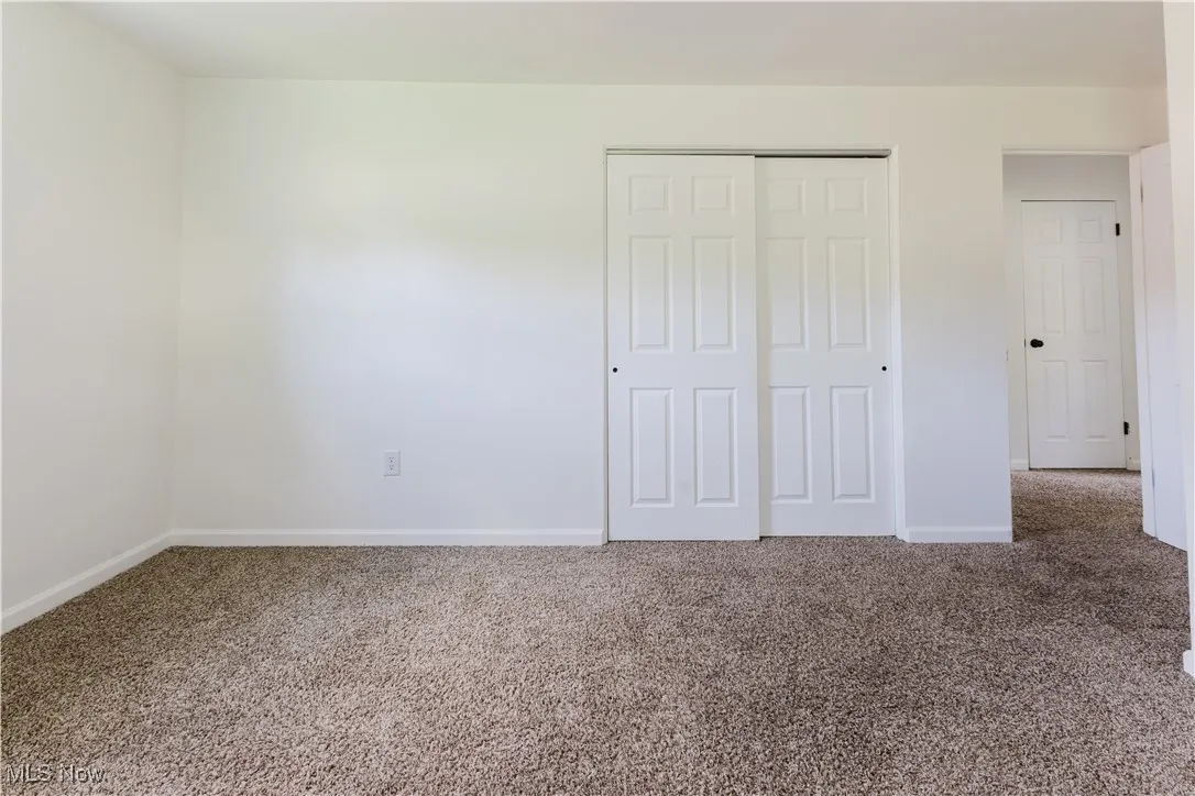 Unfurnished bedroom featuring carpet and a closet