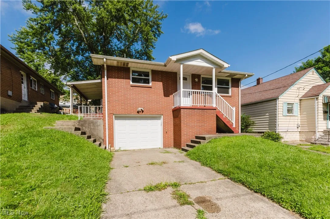 Ranch-style home featuring stairway, a porch, concrete driveway, and an attached garage