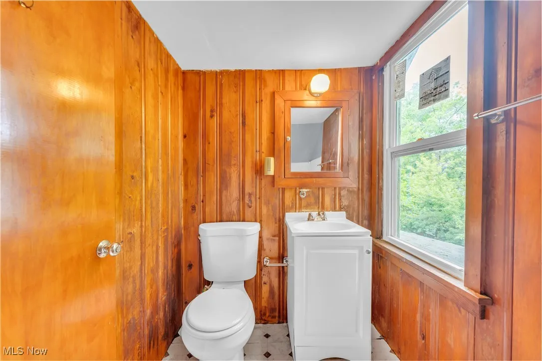 Bathroom featuring wood walls, vanity, and tile patterned flooring