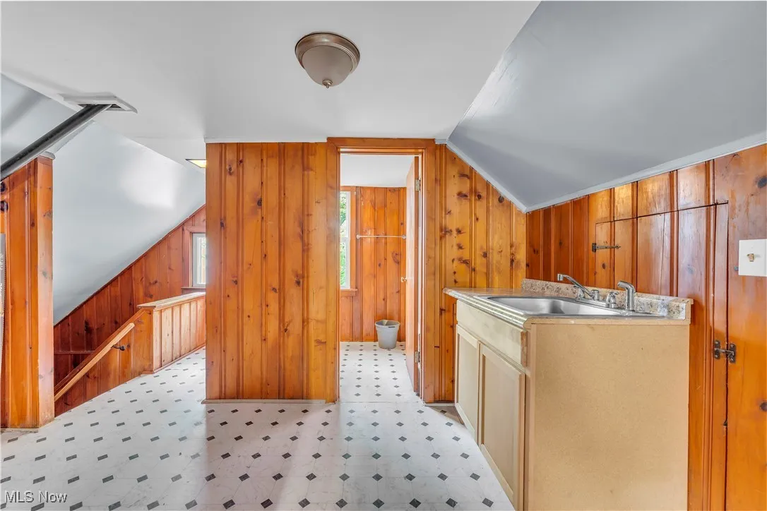 Laundry area with light floors and wood walls