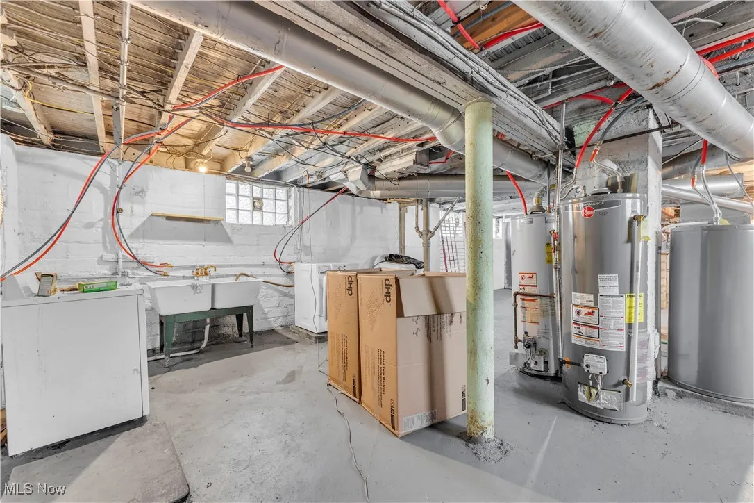 Below grade area featuring washer / clothes dryer, water heater, and gas water heater