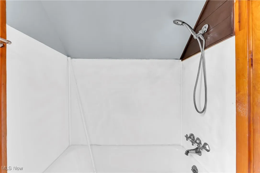 Bathroom featuring lofted ceiling and shower / bath combination