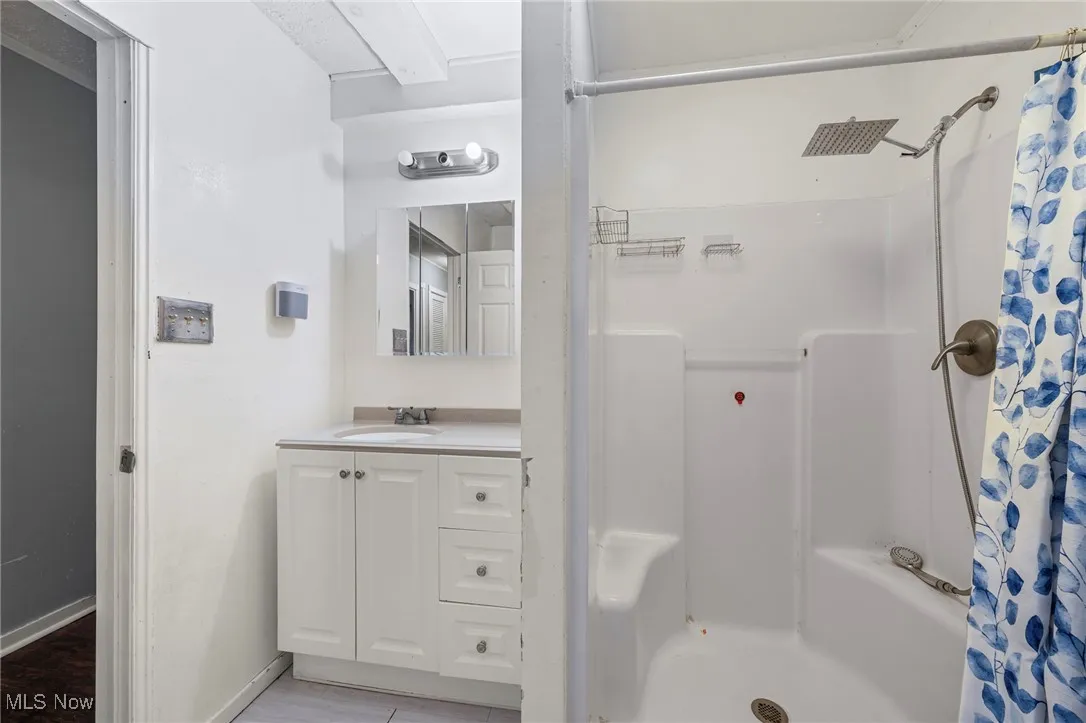 Full bath with a shower with curtain and vanity
