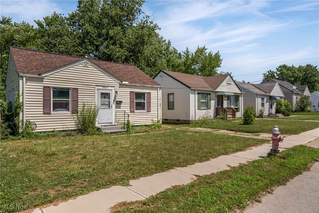 View of front facade with a front yard and roof with shingles