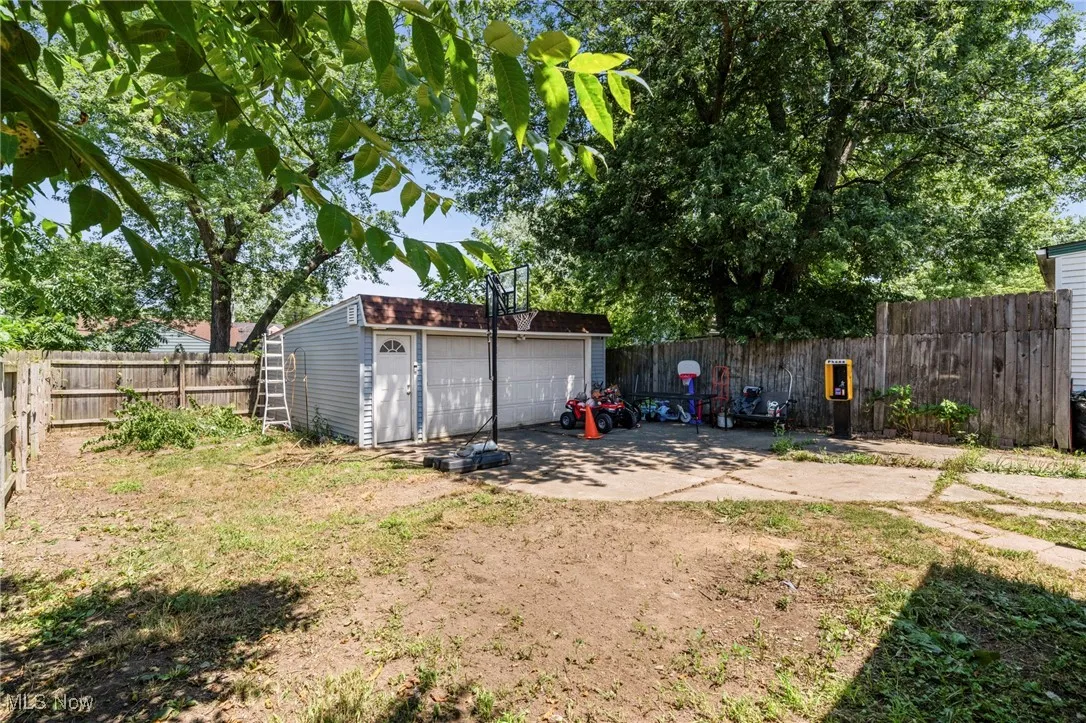 Fenced backyard with a garage and an outdoor structure