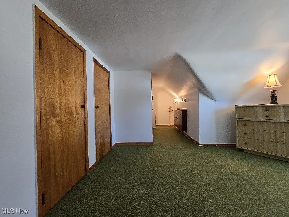 Additional living space featuring carpet flooring and baseboards