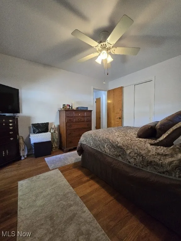 Bedroom with wood finished floors, ceiling fan, and a closet