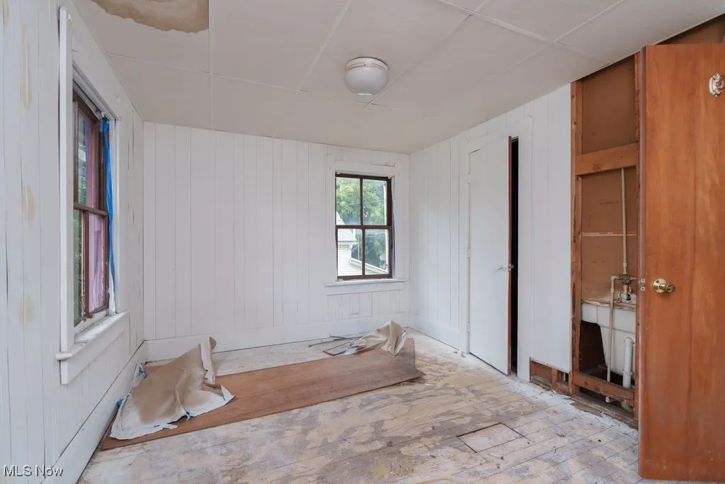 Unfurnished bedroom with wooden walls