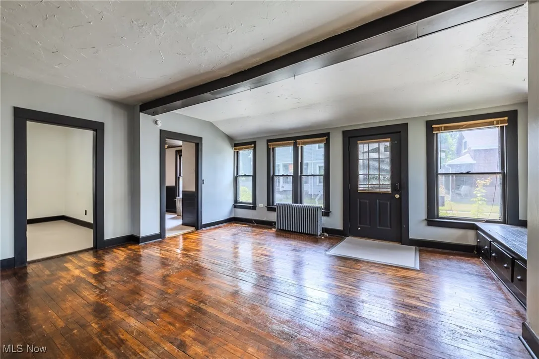 Foyer entrance featuring hardwood / wood-style floors, radiator heating unit, and a textured ceiling