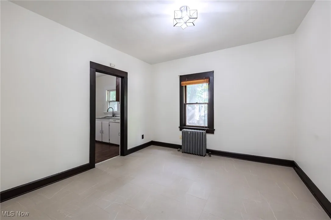 Spare room with baseboards and radiator
