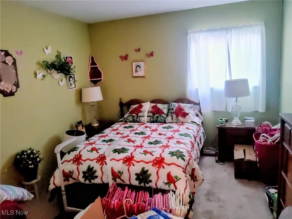 Bedroom featuring light carpet