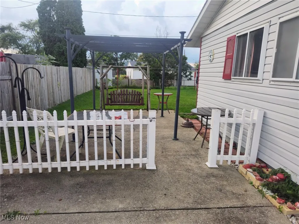 Fenced backyard featuring a pergola