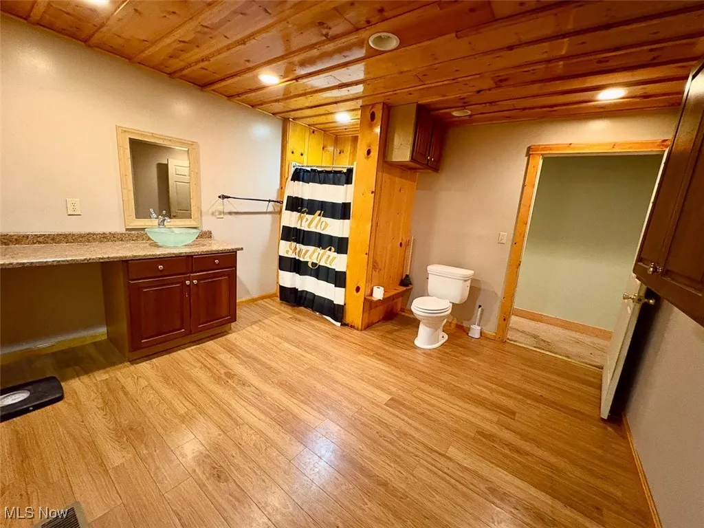 Full bath featuring vanity, wood finished floors, a shower with curtain, wood ceiling, and recessed lighting