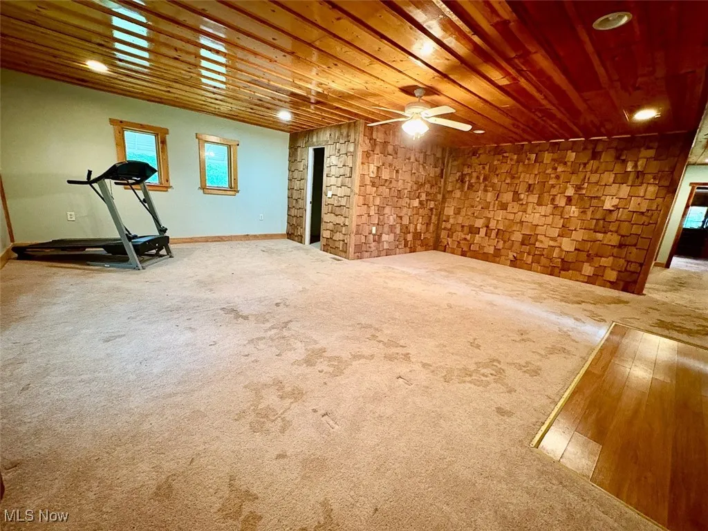 Bedroom with wooden ceiling, ceiling fan, carpet flooring, and a fireplace