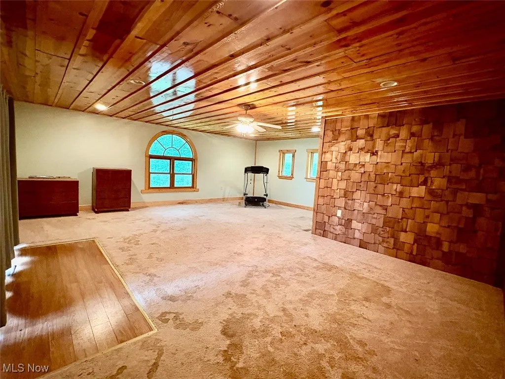 Bedroom featuring wooden ceiling, carpet, and a ceiling fan
